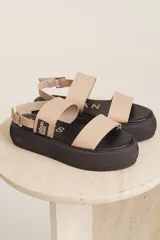 Sandalias con plataforma color beige, con dos tiras anchas sobre el empeine y tira con hebilla alrededor del tobillo.