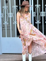 Vestido largo de gasa color rosa con estampado floral, escote halter y corte evasé.