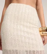 Pollera de largo new midi confeccionada en tejido de punto con aplicación de lentejuelas en toda la prenda. Presenta un diseño ajustado al cuerpo, forro interno y cintura elástica.