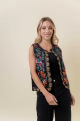 Chaleco sin mangas de base negra con bordado artesanal multicolor de inspiración floral y botánica en el frente. Diseño abierto con calce cómodo y recto.