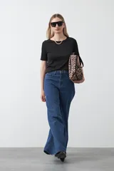 Remera de manga corta color beige claro, confeccionada en tejido acanalado elástico, con cuello redondo.