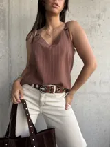 Musculosa marrón con rayas verticales blancas, escote en V y breteles con detalle de argollas.