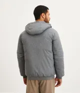 Campera deportiva azul marino con capucha ajustable, cuello alto, cierre frontal con cremallera y bolsillos laterales con cremallera.
