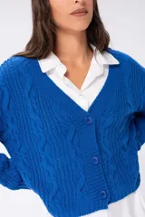 Saco tejido color marrón claro con diseño trenzado, escote en V y cierre frontal con botones marrones.