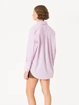 Camisa de poplin rayada rosa y celeste, de corte holgado, con cuello clásico, cierre frontal con botones y bolsillo plaqué en el pecho.