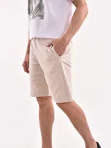Bermuda color beige con bolsillos laterales y traseros.