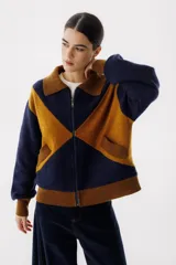 Campera bomber azul con diseño geométrico en color mostaza, cierre frontal y bolsillos laterales.