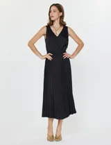 Conjunto de buzo y vestido negro marca Current Air. El vestido es de satén con escote en V y falda plisada. El buzo es de tejido calado, liviano y delicado.