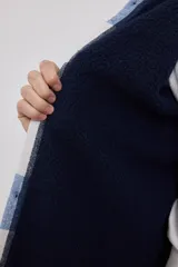 Sobrecamisa de hombre con diseño a cuadros en tonos marrón, beige y blanco. Confeccionada en tejido peludito suave, con cuello clásico, cierre frontal con botones, bolsillo superior y mangas largas con puños abotonados.