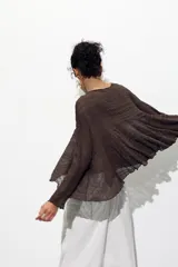 Top marrón con cuello redondo y manga larga tipo capa. Detalle de tejido con textura y bajo asimétrico.