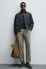 Pantalón chino de vestir negro, corte slim fit, con bolsillos laterales y traseros. Cierre frontal con cremallera y botón.