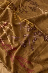 Pañuelo rectangular color marrón con estampado floral en tonos rosa, amarillo y marrón. Tiene terminaciones deshilachadas.