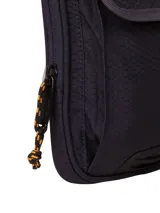Bolso pequeño tipo bandolera o riñonera de poliéster ripstop hexagonal 300D color negro asfalto, con logo CAT reflectante en la solapa. Cuenta con correa ajustable y extraíble, compartimento principal con cierre y bolsillo delantero con solapa.