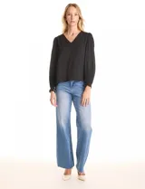 Blusa negra de gasa, marca Tahari, con escote en V y detalle de punto smock en los hombros. Manga larga con terminación plisada y puños elásticos.