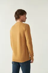Sweater mostaza de punto con cuello redondo, mangas largas y logo bordado en el pecho. Corte slim fit.