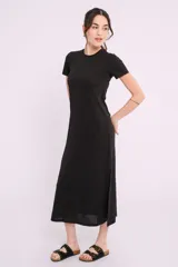 Vestido midi negro de tejido acanalado, con cuello redondo y mangas cortas. Presenta un corte recto con aberturas laterales en el ruedo.