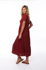 Vestido midi color borgoña, con cuello camisero, manga corta y falda escalonada.