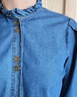 Camisa color crudo, de corte recto, con cuello mao y mangas 3/4 con detalle de puño en contraste.