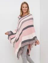 Poncho de tejido de punto color beige y salmón con diseño de rayas diagonales y cuello en V. Presenta terminación con flecos en el ruedo.