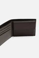 Billetera tipo cartera fabricada en piel color marrón oscuro. Cuenta con un compartimento para billetes, tres compartimentos para tarjetas, dos ranuras laterales y un monedero con cierre mediante clip.