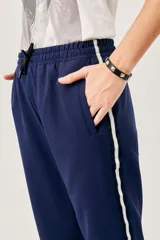 Pantalón deportivo negro con cintura elastizada y cordón de ajuste. Presenta bolsillos laterales y una franja blanca a lo largo de la pierna.