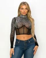 Top tipo corset de tul elastizado semi transparente color negro, con cuello alto y mangas largas. Cubierto con pedrería plateada.