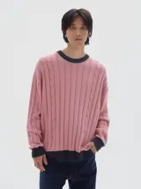 Buzo tejido de ochos color verde oscuro, con cuello a la base y rayas contratono en puños y cuello.