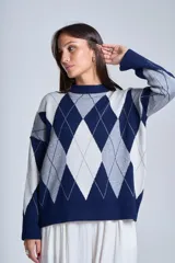 Sweater de punto con cuello redondo y diseño de rombos en tonos azul marino, gris y blanco.