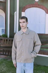 Campera de denim color beige, con cuello amplio, puños con botones y cierre frontal con botones. Incluye bolsillos en el pecho y laterales. Tejido denim de sarga resistente y con protección contra el viento.