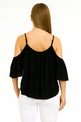 Blusa blanca con breteles finos y hombros descubiertos, corte holgado y escote redondo.