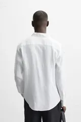 Camisa celeste de lino, de corte recto, manga larga y cuello clásico.