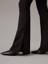 Leggings negros de punto milano, con corte slim, talle alto y pierna acampanada con bajo abierto.