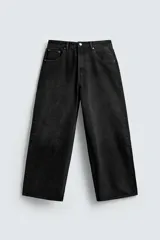 Pantalón de jeans de algodón, corte baggy fit, tiro medio, con efecto lavado en tonos grises y verdes. Presenta cinco bolsillos y cierre frontal con cremallera y botón.