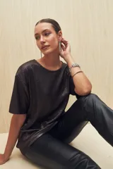 Remera negra con textura acanalada y corte holgado.