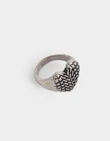 Anillo plateado con forma de corazón con textura entintada.