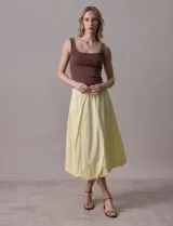 Falda midi color amarillo pálido, de algodón, con pretina ancha elastizada y forro interno a tono.