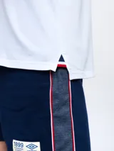 Remera polo azul con cierre, puños y cuello con detalle tricolor. Incluye logo de Umbro y escudo del Club Nacional de Football.