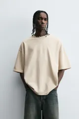 Camiseta color beige de corte holgado, cuello redondo y manga corta.
