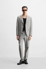 Blazer regular fit color gris claro confeccionado en tejido con lana. Tiene cuello con solapas de muesca, manga larga con puño abotonado, bolsillo de vivo en el pecho, bolsillos de solapa en la cadera, bolsillo interior, aberturas en la espalda y cierre frontal con botones.
