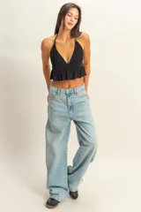 Top blanco con textura y peplum, escote halter y tirantes finos.