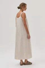 Vestido largo color beige de lino con tiras bordadas.