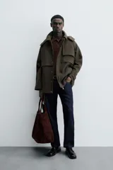 Parka verde oscuro confeccionada en tejido con lana, corte regular, cuello solapa con capucha desmontable, manga larga con puño ajustable, bolsillos de vivo en cadera y cierre frontal con cremallera oculta por solapa con botones a presión.