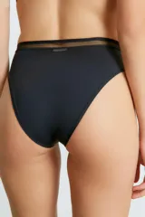 Conjunto de lencería negro, compuesto por un corpiño con breteles regulables y detalle de tul en el escote, y una bombacha vedetina con detalle de tul en la cintura.