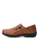 Zapato casual de mujer color marrón claro, estilo mocasín con costuras decorativas en la puntera y elástico negro cruzado en el empeine. Posee suela negra gruesa y ergonómica.