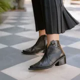 Botines de cuero vacuno color blanco con diseño bordado, taco de madera foliado en cuero de 5cm, cierre del lado interior y horma de punta fina.