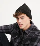 Gorro de tejido acrílico negro con diseño acanalado y trenzado en la parte superior.