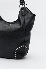 Bolso shopper negro de símil cuero texturizado con asas de hombro y detalles de tachas metálicas.