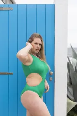 Traje de baño entero color verde con textura, un hombro descubierto y abertura lateral en la cintura.