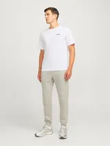 Camiseta blanca de manga corta y cuello redondo con logo 'JJ Rebel' estampado en el pecho.