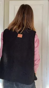 Chaleco reversible con un lado de corderito negro y otro de tussor con estampado animal print.